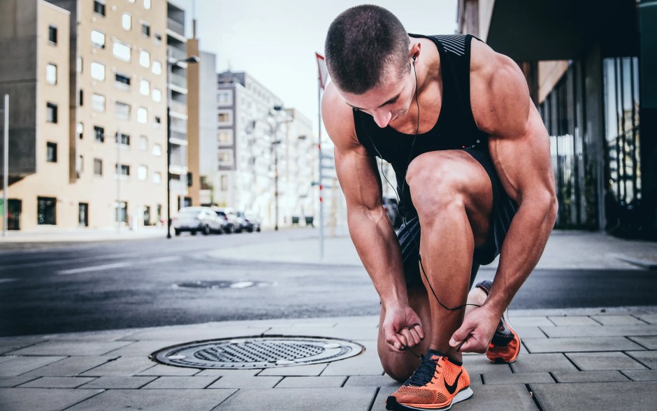 alexander-redl-d3bYmnZ0ank-unsplash | SpainGuru man in sports gear tying his shoelaces