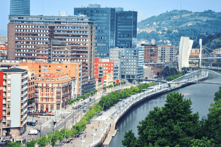 A collage of Bilbao's culture, including a delicious spread of pintxos, the green Basque countryside, and a local festival