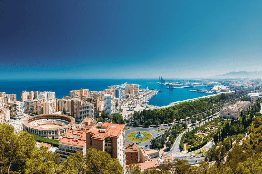 Panoramic view of Málaga coastline, port, and city skyline under a sunny sky